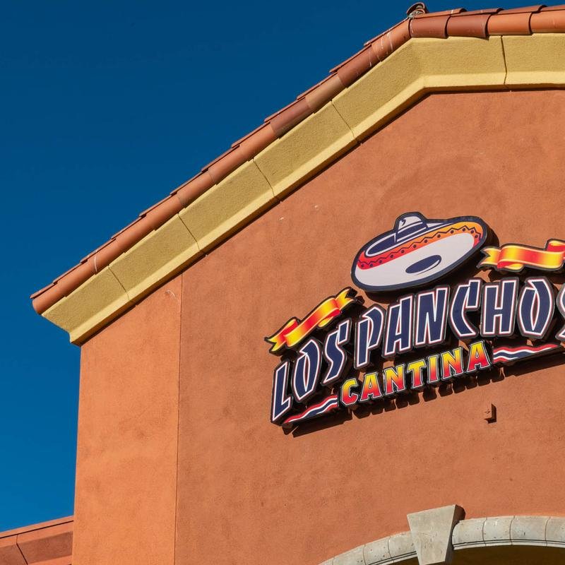 Mexican grill storefront with outdoor seating.