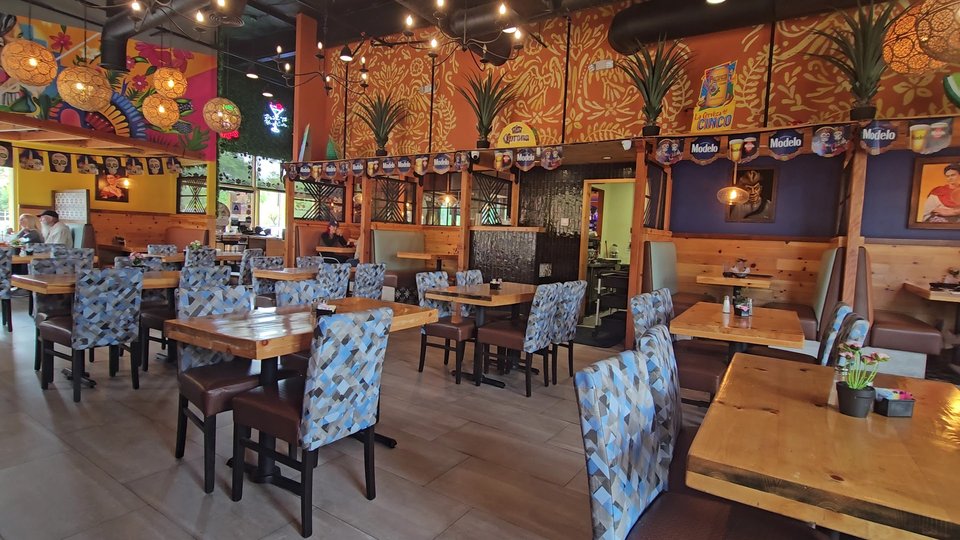 Colorful Mexican plates on a busy restaurant table.