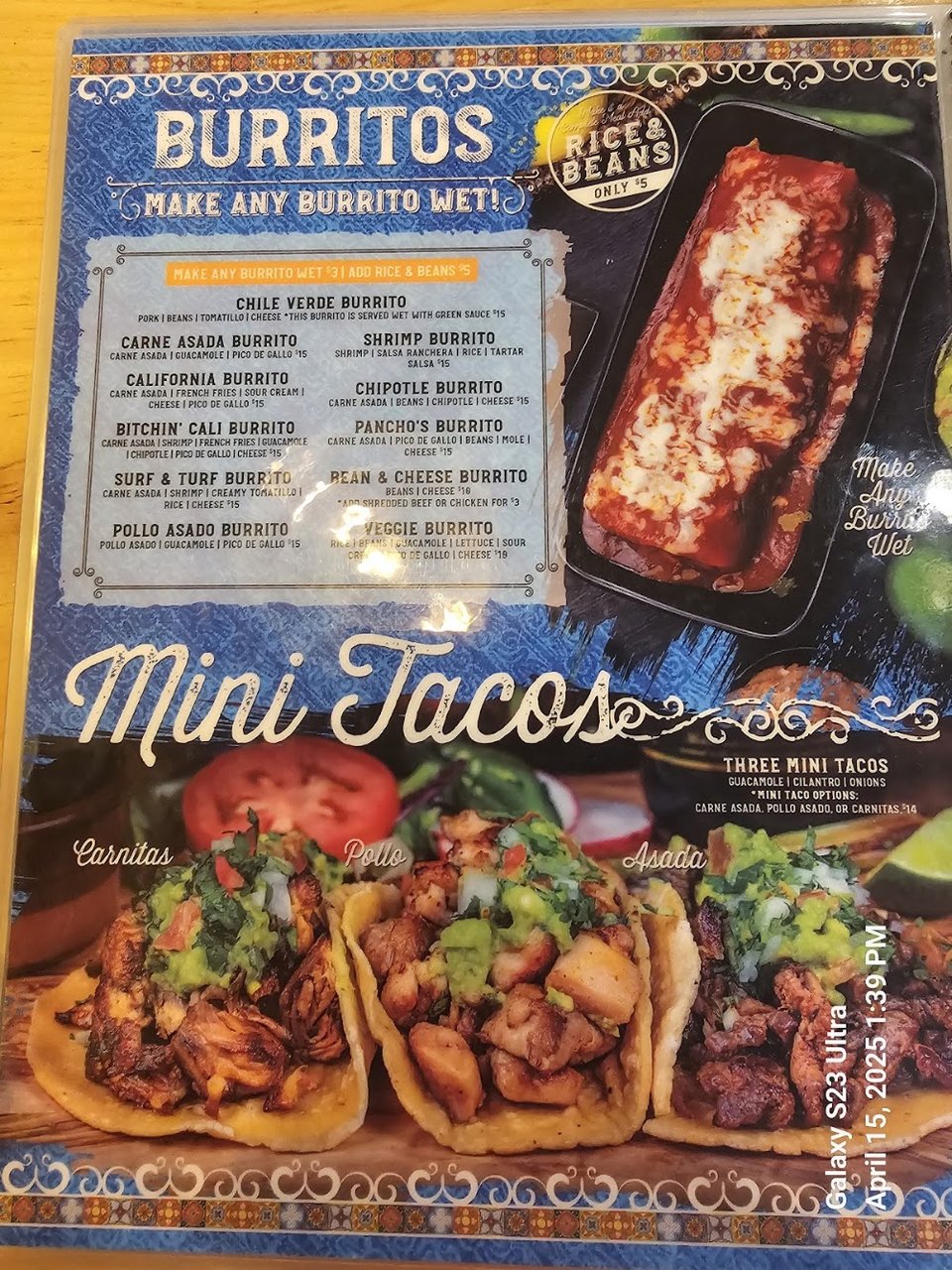 Close-up of a menu beside a drink glass.